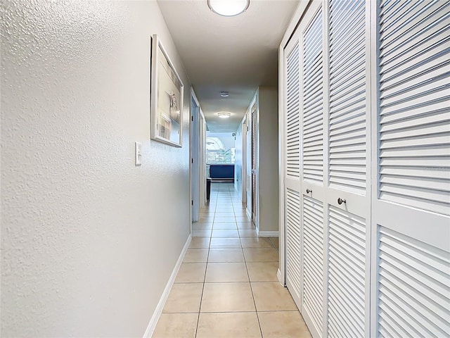 8704 Knightsbridge Ct Unit B, Kissimmee, FL 34747 - corridor featuring light tile patterned floors, a textured wall, and baseboards