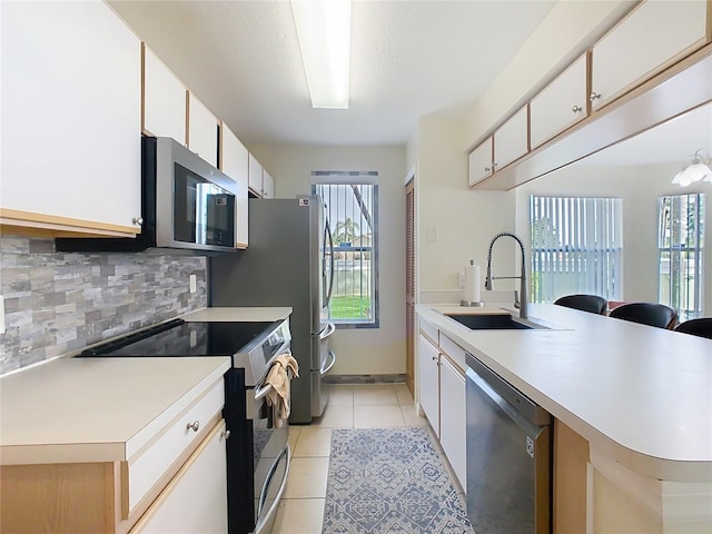 8704 Knightsbridge Ct Unit B, Kissimmee, FL 34747 - kitchen featuring appliances with stainless steel finishes, a sink, decorative backsplash, light countertops, and light tile patterned floors