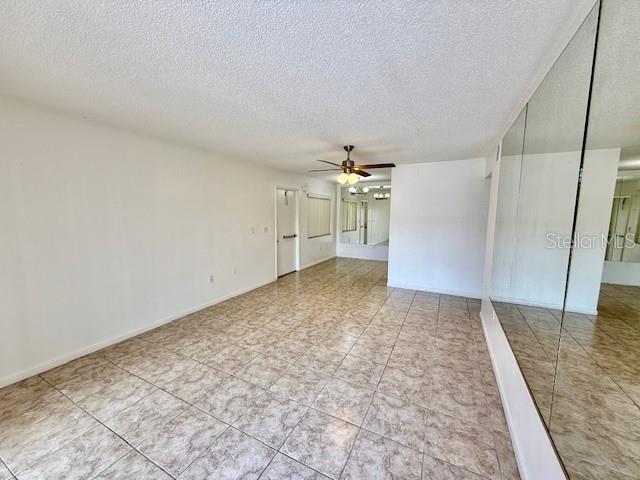 5269 Vineland Rd Unit 101, Orlando, FL 32811 - tiled empty room with ceiling fan and a textured ceiling