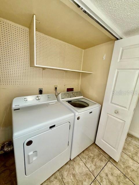 5269 Vineland Rd Unit 101, Orlando, FL 32811 - laundry room featuring washer and clothes dryer and light tile patterned flooring