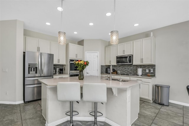 1821 Benevento St, Saint Cloud, FL 34771 - kitchen with stainless steel appliances, tasteful backsplash, a center island with sink, white cabinetry, and recessed lighting
