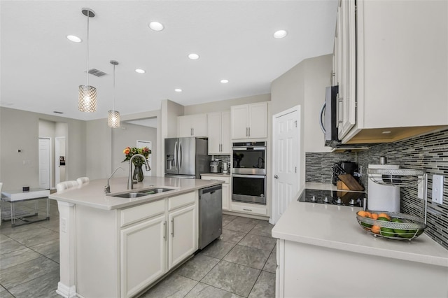 1821 Benevento St, Saint Cloud, FL 34771 - kitchen featuring appliances with stainless steel finishes, a sink, backsplash, recessed lighting, and a center island with sink