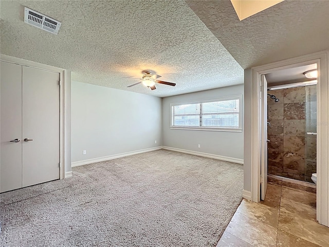 7679 Bent Bow Trl, Winter Park, FL 32792 - unfurnished bedroom featuring light carpet, a textured ceiling, ensuite bathroom, a closet, and a ceiling fan