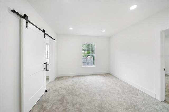 161 Bolender Rd, Auburndale, FL 33823 - unfurnished bedroom with a barn door, carpet floors, recessed lighting, and baseboards
