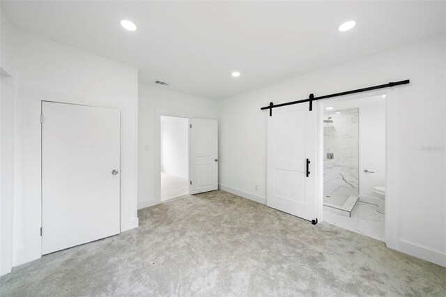 161 Bolender Rd, Auburndale, FL 33823 - unfurnished bedroom featuring a barn door, recessed lighting, carpet floors, connected bathroom, and baseboards