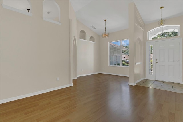 3014 Linmont Ln, Eustis, FL 32726 - foyer with a chandelier, wood finished floors, a towering ceiling, and baseboards