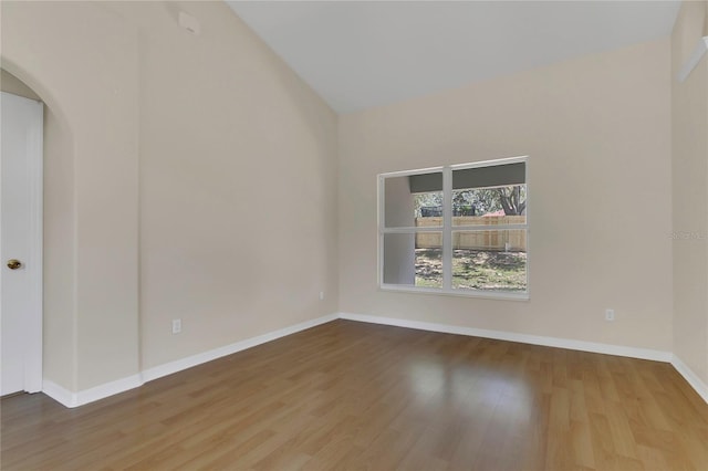 3014 Linmont Ln, Eustis, FL 32726 - spare room with wood finished floors, baseboards, arched walkways, and high vaulted ceiling