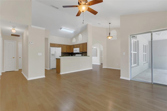3014 Linmont Ln, Eustis, FL 32726 - unfurnished living room with arched walkways, ceiling fan, light wood-type flooring, baseboards, and high vaulted ceiling