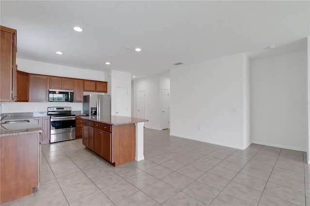 3953 Baja Dr, Saint Cloud, FL 34772 - kitchen featuring appliances with stainless steel finishes, a kitchen island, recessed lighting, light tile patterned floors, and light stone countertops