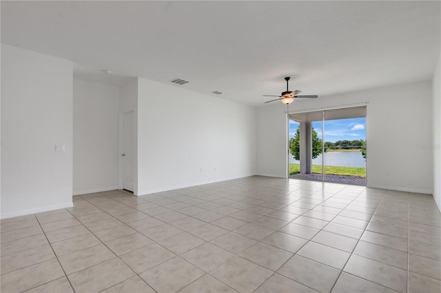 3953 Baja Dr, Saint Cloud, FL 34772 - unfurnished room featuring a ceiling fan, light tile patterned flooring, a water view, and baseboards