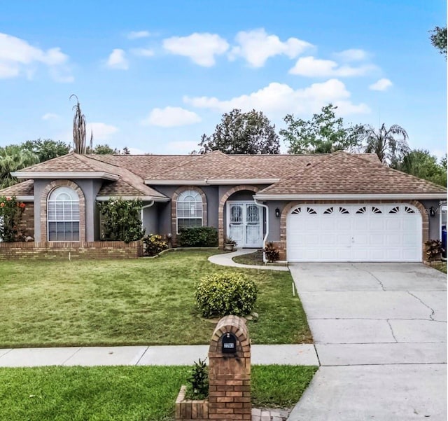2203 Essex Dr, Ocoee, FL 34761 - ranch-style house with an attached garage, a front lawn, driveway, and roof with shingles
