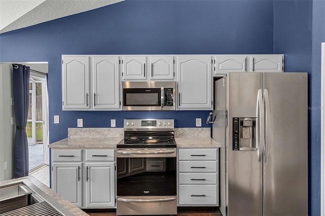 2203 Essex Dr, Ocoee, FL 34761 - kitchen featuring stainless steel appliances, light countertops, white cabinets, and lofted ceiling