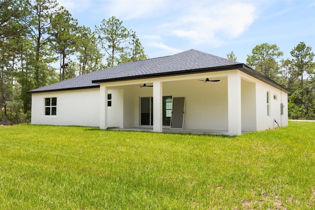 13619 SW 78th Pl, Dunnellon, FL 34432 - rear view of house featuring a ceiling fan, stucco siding, roof with shingles, and a yard