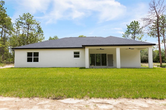 13619 SW 78th Pl, Dunnellon, FL 34432 - back of house featuring a ceiling fan, stucco siding, a yard, and a shingled roof