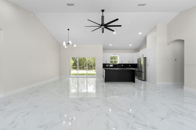 13619 SW 78th Pl, Dunnellon, FL 34432 - unfurnished living room with arched walkways, high vaulted ceiling, ceiling fan, light marble finish flooring, and a chandelier
