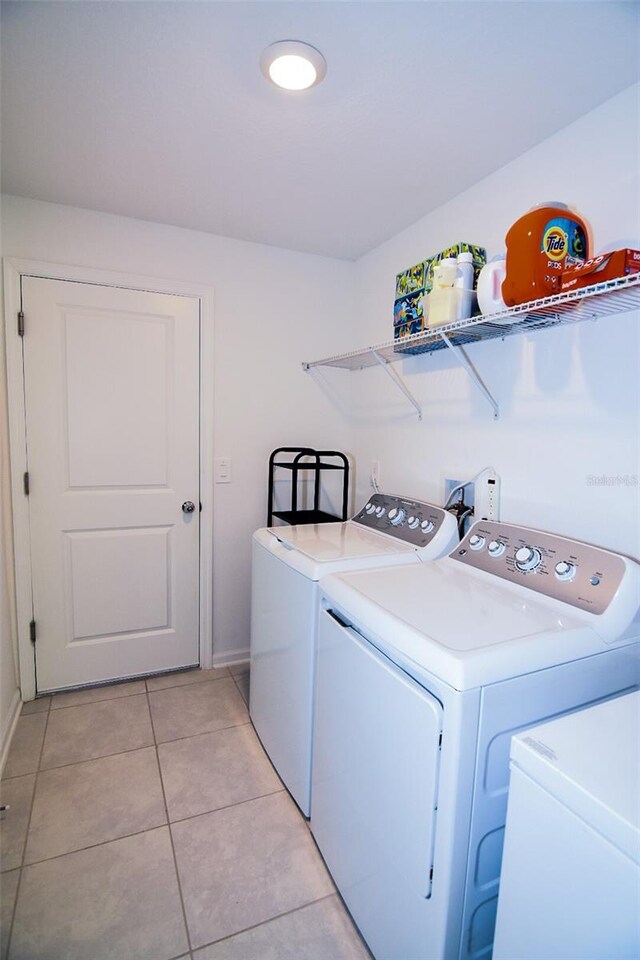 214 Brave Rd, Davenport, FL 33837 - laundry area featuring washing machine and clothes dryer, baseboards, and light tile patterned floors