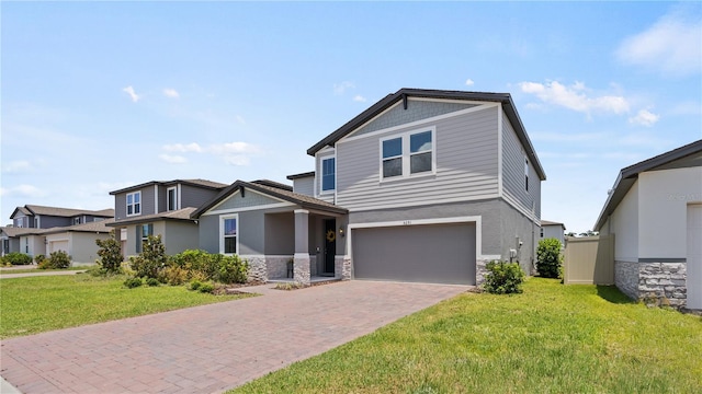 5291 Meredrew Ln, Saint Cloud, FL 34771 - view of front of home featuring stone siding, a garage, a front lawn, decorative driveway, and stucco siding