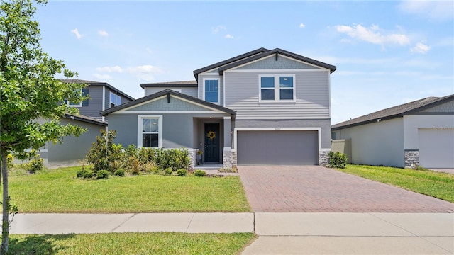 5291 Meredrew Ln, Saint Cloud, FL 34771 - craftsman-style home featuring decorative driveway, a front lawn, stone siding, an attached garage, and stucco siding