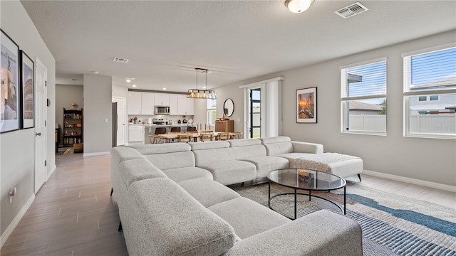 5291 Meredrew Ln, Saint Cloud, FL 34771 - living area featuring light wood-type flooring, baseboards, recessed lighting, and a chandelier
