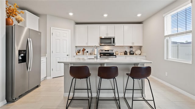 5291 Meredrew Ln, Saint Cloud, FL 34771 - kitchen featuring appliances with stainless steel finishes, a sink, tasteful backsplash, light countertops, and white cabinetry