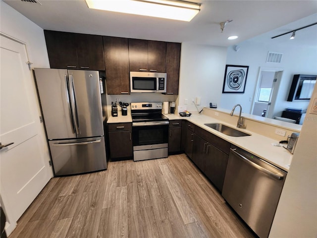 14501 Grove Resort Ave Unit 3737, Winter Garden, FL 34787 - kitchen with stainless steel appliances, a sink, light countertops, and light wood-type flooring