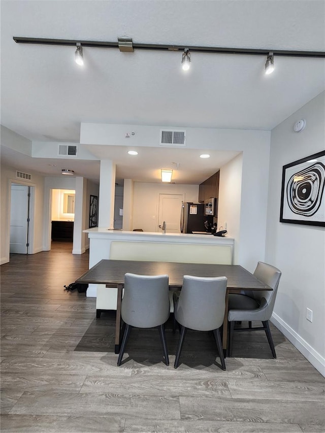14501 Grove Resort Ave Unit 3737, Winter Garden, FL 34787 - kitchen with track lighting, baseboards, freestanding refrigerator, wood finished floors, and a peninsula