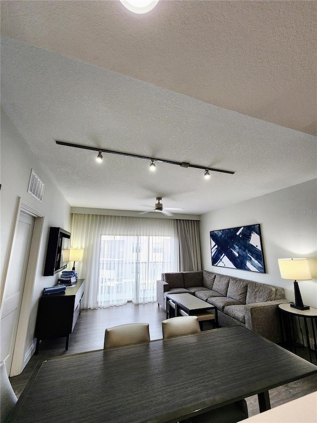 14501 Grove Resort Ave Unit 3737, Winter Garden, FL 34787 - living room featuring a textured ceiling, track lighting, a ceiling fan, and dark wood-type flooring