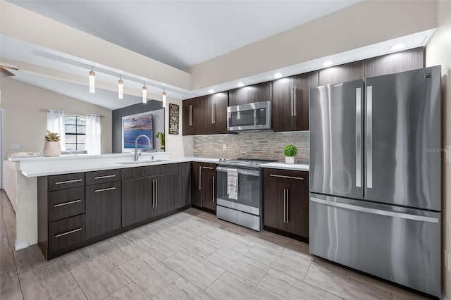 5729 Norman H Cutson Dr, Orlando, FL 32821 - kitchen featuring stainless steel appliances, light countertops, a sink, dark brown cabinetry, and tasteful backsplash