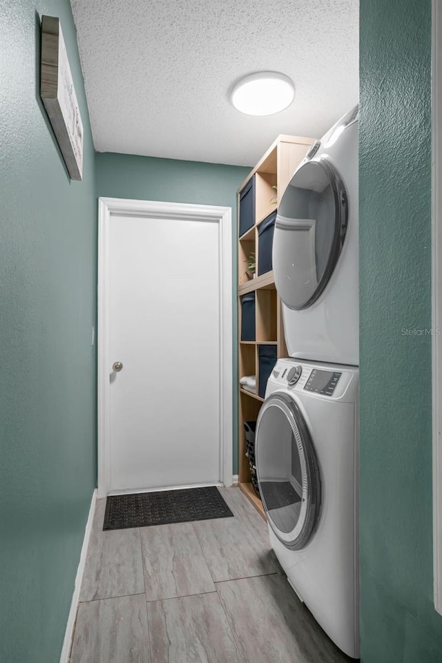 5729 Norman H Cutson Dr, Orlando, FL 32821 - laundry area with stacked washer / dryer, a textured ceiling, wood finished floors, and baseboards