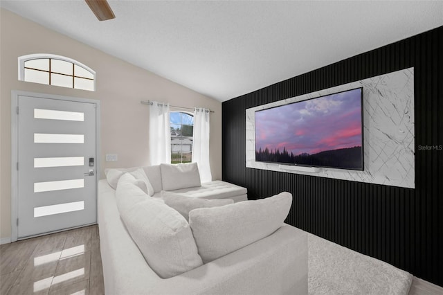 5729 Norman H Cutson Dr, Orlando, FL 32821 - living area featuring an accent wall, vaulted ceiling, and wood finished floors