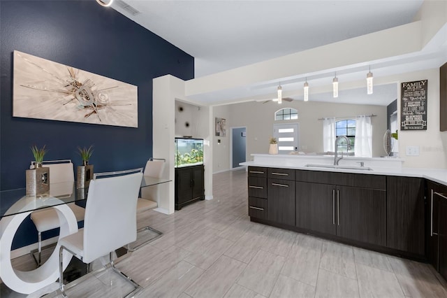 5729 Norman H Cutson Dr, Orlando, FL 32821 - kitchen with a sink, light countertops, lofted ceiling, a peninsula, and decorative light fixtures