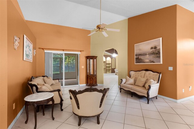 2888 Middleton Cir, Kissimmee, FL 34743 - living room with arched walkways, ceiling fan, high vaulted ceiling, baseboards, and light tile patterned flooring