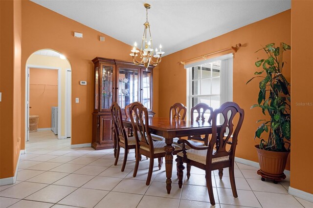 2888 Middleton Cir, Kissimmee, FL 34743 - dining area with arched walkways, a chandelier, vaulted ceiling, baseboards, and light tile patterned flooring