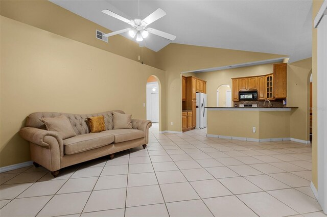 2888 Middleton Cir, Kissimmee, FL 34743 - living room featuring arched walkways, ceiling fan, light tile patterned floors, baseboards, and high vaulted ceiling