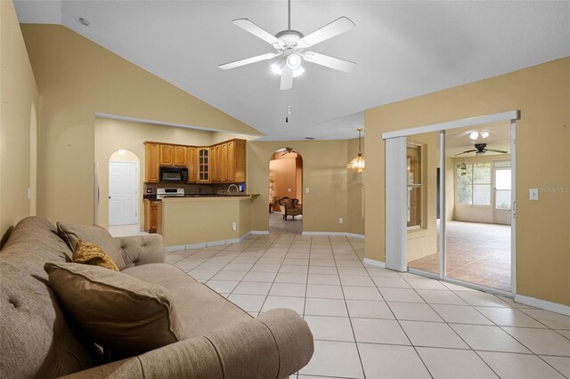 2888 Middleton Cir, Kissimmee, FL 34743 - living area featuring arched walkways, a ceiling fan, light tile patterned floors, baseboards, and high vaulted ceiling