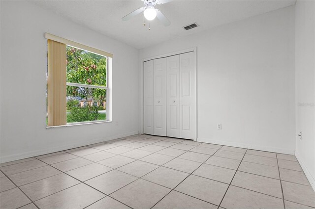 2888 Middleton Cir, Kissimmee, FL 34743 - unfurnished bedroom featuring light tile patterned floors, a closet, baseboards, and a ceiling fan