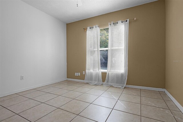 2888 Middleton Cir, Kissimmee, FL 34743 - empty room with light tile patterned floors, a textured ceiling, and baseboards