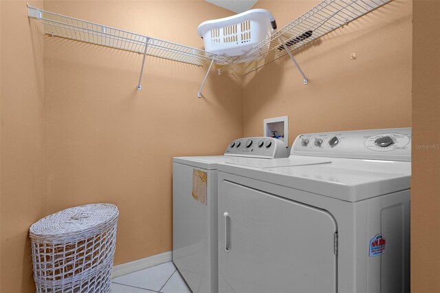 2888 Middleton Cir, Kissimmee, FL 34743 - washroom featuring washing machine and clothes dryer, light tile patterned flooring, and baseboards