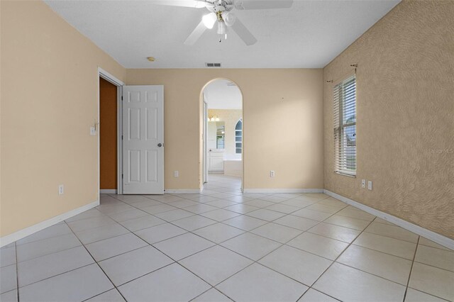 2888 Middleton Cir, Kissimmee, FL 34743 - unfurnished room featuring arched walkways, ceiling fan, light tile patterned flooring, and baseboards