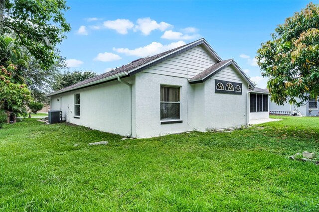 2888 Middleton Cir, Kissimmee, FL 34743 - view of property exterior featuring central air condition unit, a lawn, and stucco siding