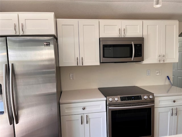 1834 28th Ave N, Saint Petersburg, FL 33713 - kitchen featuring appliances with stainless steel finishes, light countertops, and white cabinets