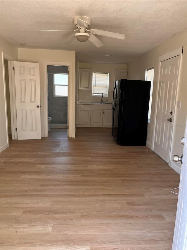1834 28th Ave N, Saint Petersburg, FL 33713 - kitchen featuring freestanding refrigerator, a sink, light wood-style floors, ceiling fan, and a textured ceiling