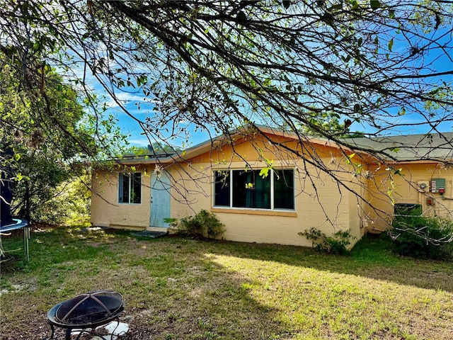 2 Clear Pl, Ocala, FL 34472 - view of front of home featuring a trampoline, an outdoor fire pit, a front yard, and concrete block siding