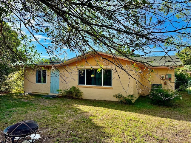 2 Clear Pl, Ocala, FL 34472 - rear view of house with an outdoor fire pit, a yard, and concrete block siding