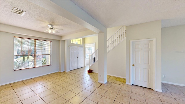 8520 La Isla Dr, Kissimmee, FL 34747 - entrance foyer featuring a textured ceiling, a ceiling fan, stairway, light tile patterned floors, and baseboards