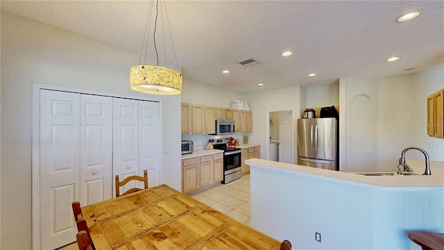 8520 La Isla Dr, Kissimmee, FL 34747 - kitchen featuring appliances with stainless steel finishes, a sink, recessed lighting, a peninsula, and light tile patterned flooring