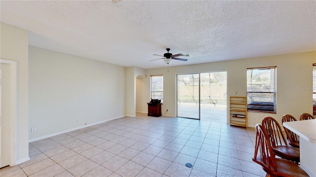 8520 La Isla Dr, Kissimmee, FL 34747 - living room featuring ceiling fan, a textured ceiling, light tile patterned floors, and baseboards