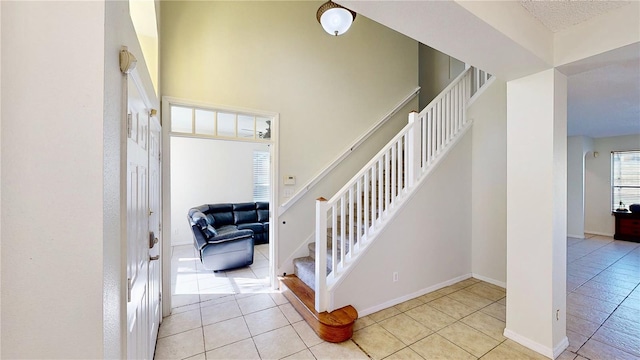 8520 La Isla Dr, Kissimmee, FL 34747 - stairway with tile patterned flooring, baseboards, and a towering ceiling