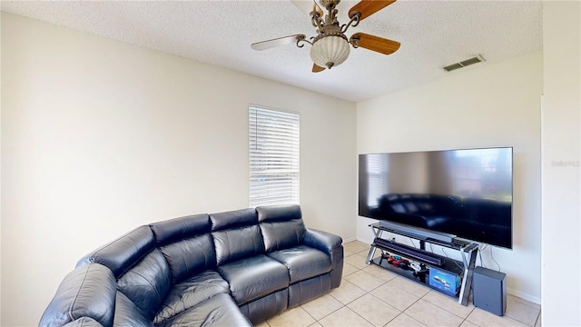 8520 La Isla Dr, Kissimmee, FL 34747 - living room with ceiling fan, a textured ceiling, light tile patterned floors, and baseboards