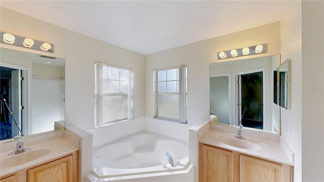 8520 La Isla Dr, Kissimmee, FL 34747 - bathroom featuring two vanities and a garden tub